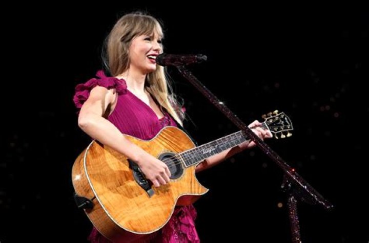 Taylor Swift playing guitar on her Eras Tour